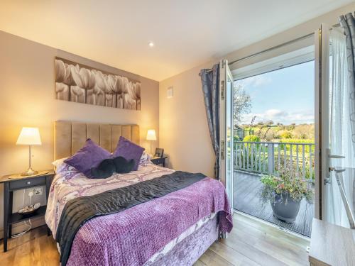a bedroom with a bed and a balcony at Ty Teiliwr - Uk45719 in Brynteg