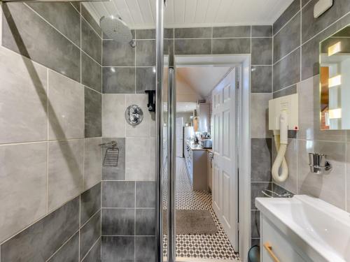 a bathroom with a shower and a sink at Ty Teiliwr - Uk45719 in Brynteg