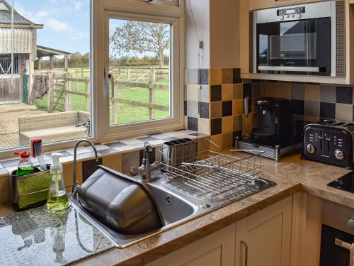 a kitchen counter with a sink and a window at Chapel Farm in Stelling