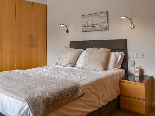 a bedroom with a large bed and a wooden cabinet at Chapel Farm in Stelling