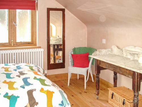 Foulsham的住宿－Bayfield Plus，卧室配有1张床、1张桌子和1把椅子
