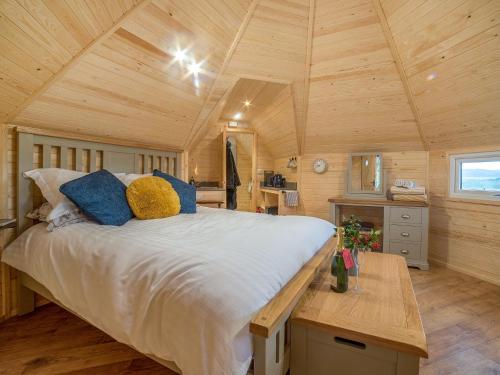 a large bed in a room with a wooden ceiling at Cwt Celyn-qu7605 in Llangerniew