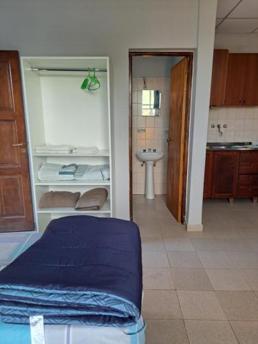 a room with a bed and a bathroom with a sink at Depto monoambiente temporario in Resistencia