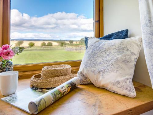 ventana con almohadas y vistas a un campo de golf en Little Swinton - Garden Cottage en Swinton