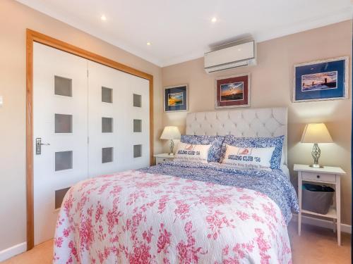 a bedroom with a large bed with a white headboard at Anchor Cottage in South Hayling