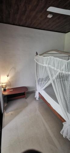 a bedroom with a bed with a mosquito net at Jeevaka Villa & Ayurveda Retreat in Galle