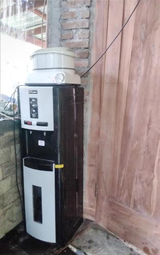 a coffee machine sitting next to a wooden wall at De Ikut Bojo Homestay in Magelang