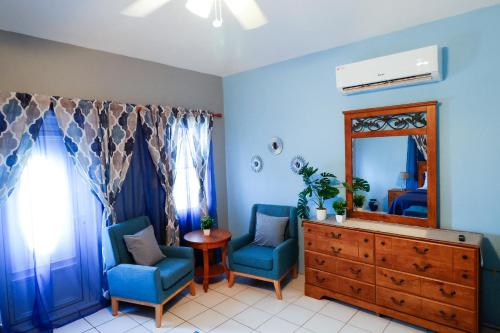 a room with two chairs and a dresser and a mirror at C&D Residential Penthouse in The Valley