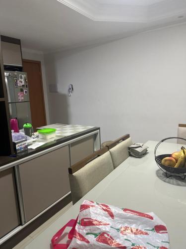 uma cozinha com um balcão e uma taça de fruta numa mesa em Lindo apartamento de 2 quartos com suite e sacada com churrasqueira em Pinhais