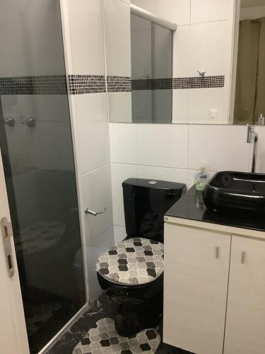 ein Bad mit einem schwarzen WC und einer Dusche in der Unterkunft Ap Girassol 77 in São Paulo
