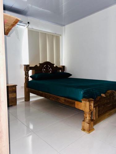a bedroom with a wooden bed with a green sheets at Apartamentos turísticos Mirador de la 20 in San Andrés