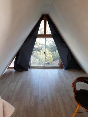 an attic room with a window and a wooden floor at Casa campestre 6 personas in San Antonio