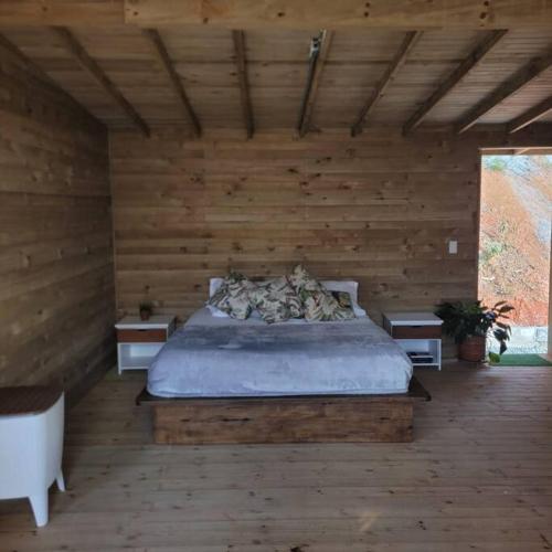 a bedroom with a bed in a wooden wall at Kuyana Glamping in Cali