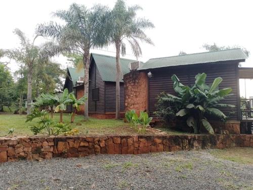 a house with a stone wall in front of it at Cabañas Misioneras in San Ignacio