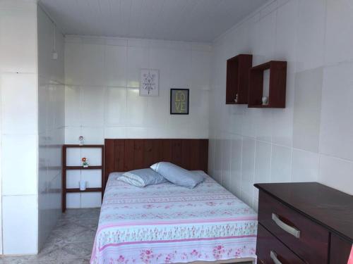 ein kleines Schlafzimmer mit einem Bett und einer Kommode in der Unterkunft Hospedaria Mirante da maré ap6 in Imbituba
