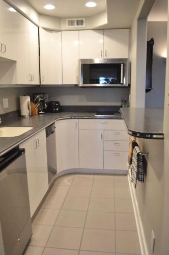 a kitchen with white cabinets and a microwave at 1-Bedroom Seaview Guesthouse on Seattle Luxury Estate with Views of Olympic Mountains in Seattle