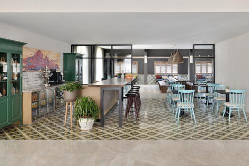 a kitchen and dining room with tables and chairs at Port Muziris, A Tribute Portfolio Hotel by Marriott in Nedumbassery