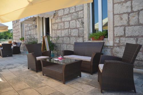 a patio with chairs and tables and an umbrella at Hotel Borik in Lumbarda