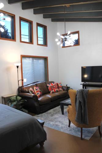 a living room with a couch and a television at Private Bright Modern Studio! Queen bed ! in Victoria