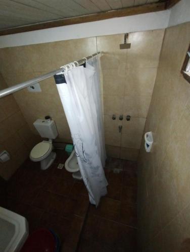 a bathroom with a shower with a toilet and a shower curtain at Posada La Justy EZEIZA in Ezeiza