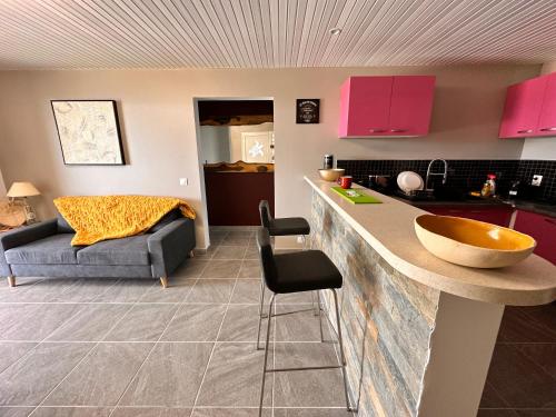 eine Küche mit rosa Schränken und einer Arbeitsplatte in der Unterkunft Havre de paix, en atlantique ! in Sainte-Marie