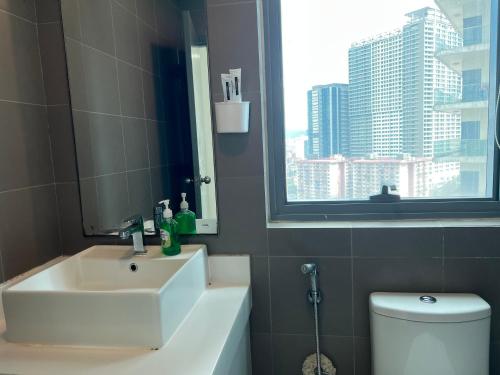 een badkamer met een wastafel, een toilet en een raam bij Summer suites victory house in Kuala Lumpur