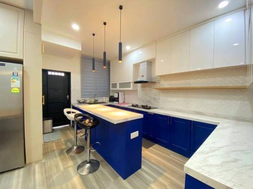 a large kitchen with blue cabinets and a counter at Modern Cozy House 4Room10pax @Near Sunway Carnival in Perai