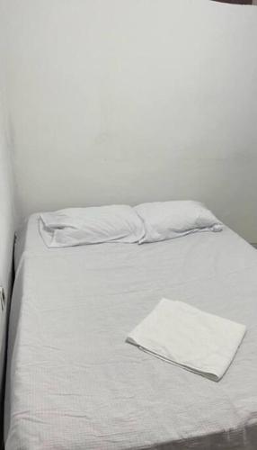 un letto con lenzuola bianche e un tovagliolo sopra di Casa com piscina em Tutóia a Tutóia