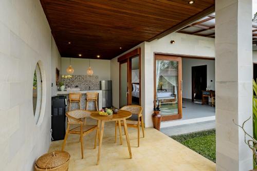 a kitchen and dining room with a table and chairs at Suarga Loka Ubud Villa in Ubud