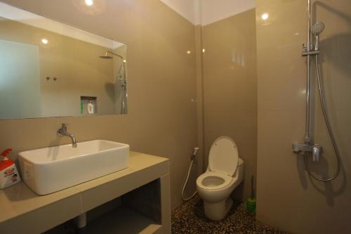 a bathroom with a sink and a toilet and a shower at Relax Beach Resort Candidasa in Candidasa