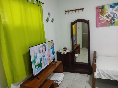 ein Wohnzimmer mit einem TV und einem Spiegel in der Unterkunft Hospedaje Casa Pachi en Cartagena de Indias in Cartagena de Indias