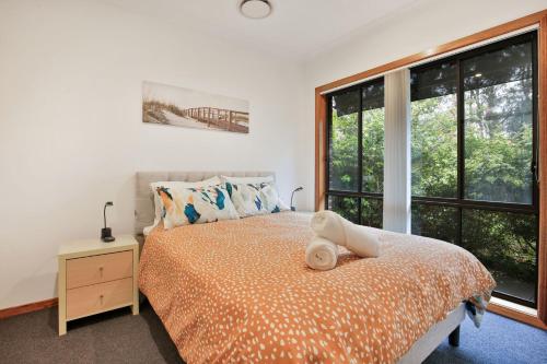 a bedroom with a bed and a large window at Tangerine - Pet Friendly - 3 Mins Walk to Beach in Sanctuary Point