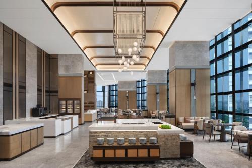 an office lobby with tables and chairs and windows at Zhuhai Marriott Hotel Jinwan in Zhuhai