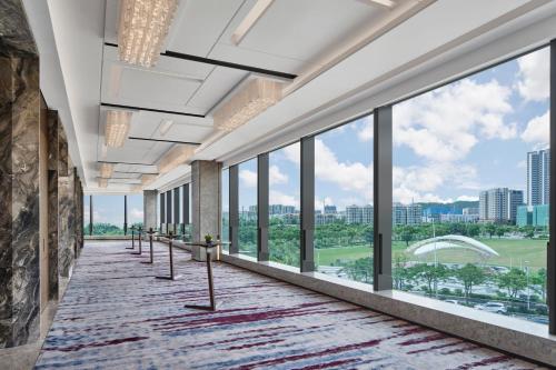 a hallway with large windows with a view of the city at Zhuhai Marriott Hotel Jinwan in Zhuhai