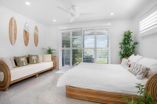 a bedroom with a large bed and a couch at 1-46 Manooka Drive - Rainbow Beach Aircon. Wifi. Pool. View in Rainbow Beach