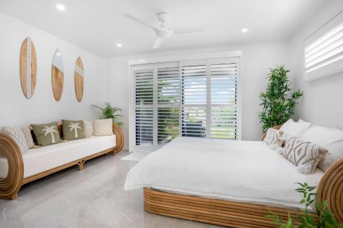彩虹海滩1-46 Manooka Drive - Rainbow Beach Aircon. Wifi. Pool. View的带一张大床和一张沙发的卧室