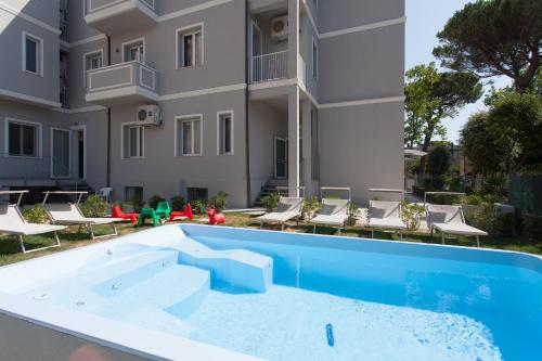 an apartment with a swimming pool in front of a building at Hotel Star in Cesenatico
