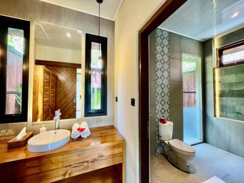 uma casa de banho com um lavatório e um WC em The Papas Villas em Tegalalang