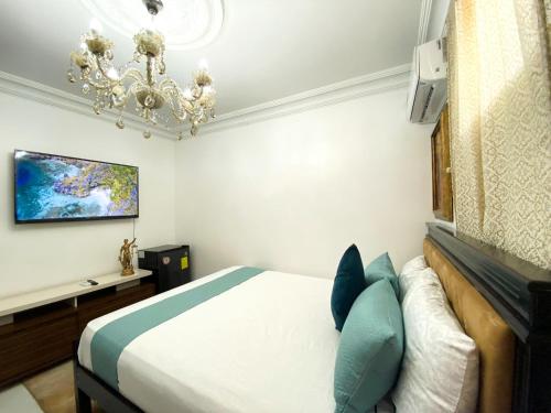 een slaapkamer met een bed en een kroonluchter bij Habitación a cinco minutos del aeropuerto y terminal terrestre in Guayaquil