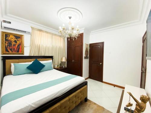 um quarto com uma cama e um lustre em Habitación a cinco minutos del aeropuerto y terminal terrestre em Guayaquil