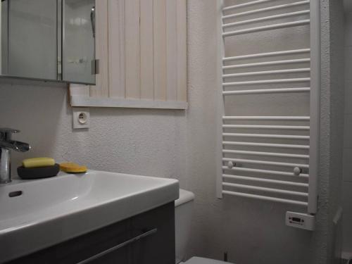 a white bathroom with a sink and a toilet at Studio Font-Romeu-Odeillo-Via, 1 pièce, 2 personnes - FR-1-580-102 in Font-Romeu-Odeillo-Via
