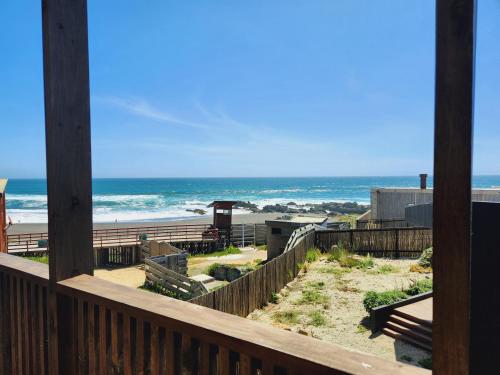 a view of the beach from the deck of a beach house at Espectacular Casa Palafito frente al mar in Pichilemu
