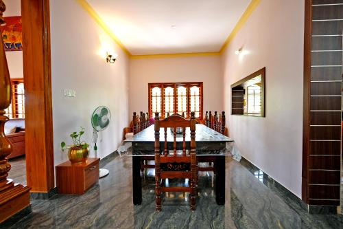 comedor con mesa y sillas en Kodebailu Homestay - 3BH Full Villa, Home Food, Coffee Estate, en Sakleshpur