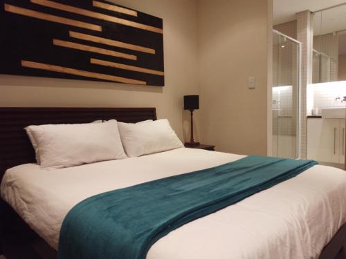 um quarto com uma cama com um cobertor verde em Business Pro Apartment, Windhoek em Windhoek