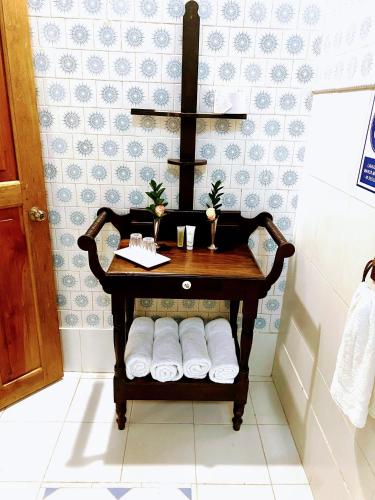 a bathroom with a table with towels and a cross at CASA SINNING-año1637 in Mompos