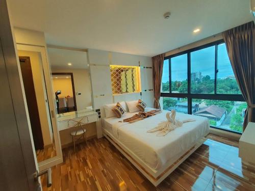 a bedroom with a large bed with a large window at Doi Sutep Hill in Chiang Mai