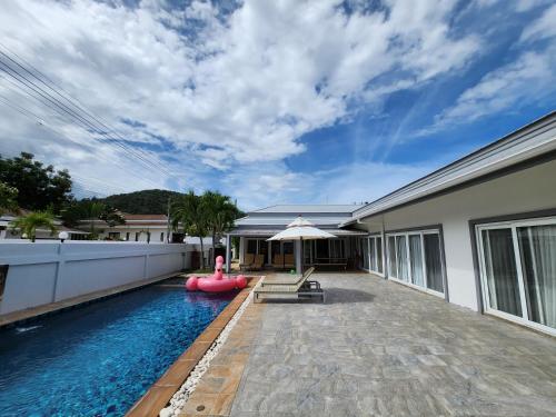 a house with a swimming pool with a red inflatableermott at ปุณิกา พูล วิลล่า หัวหิน Punika Pool Villa Hua Hin in Hua Hin
