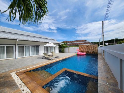 a swimming pool in the backyard of a house at ปุณิกา พูล วิลล่า หัวหิน Punika Pool Villa Hua Hin in Hua Hin