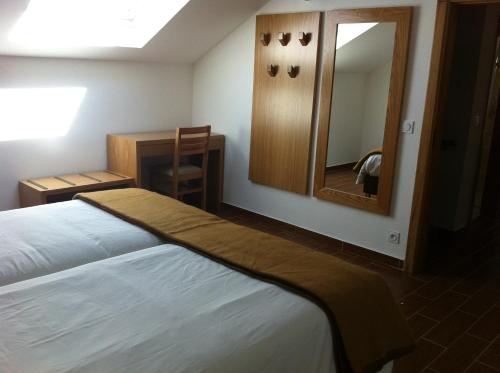 a hotel room with a bed and a mirror at Gites Des Sablons in Châtillon-sur-Marne