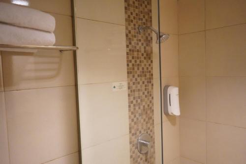 a shower with a glass door in a bathroom at Syariah Hotel Sentul in Bogor